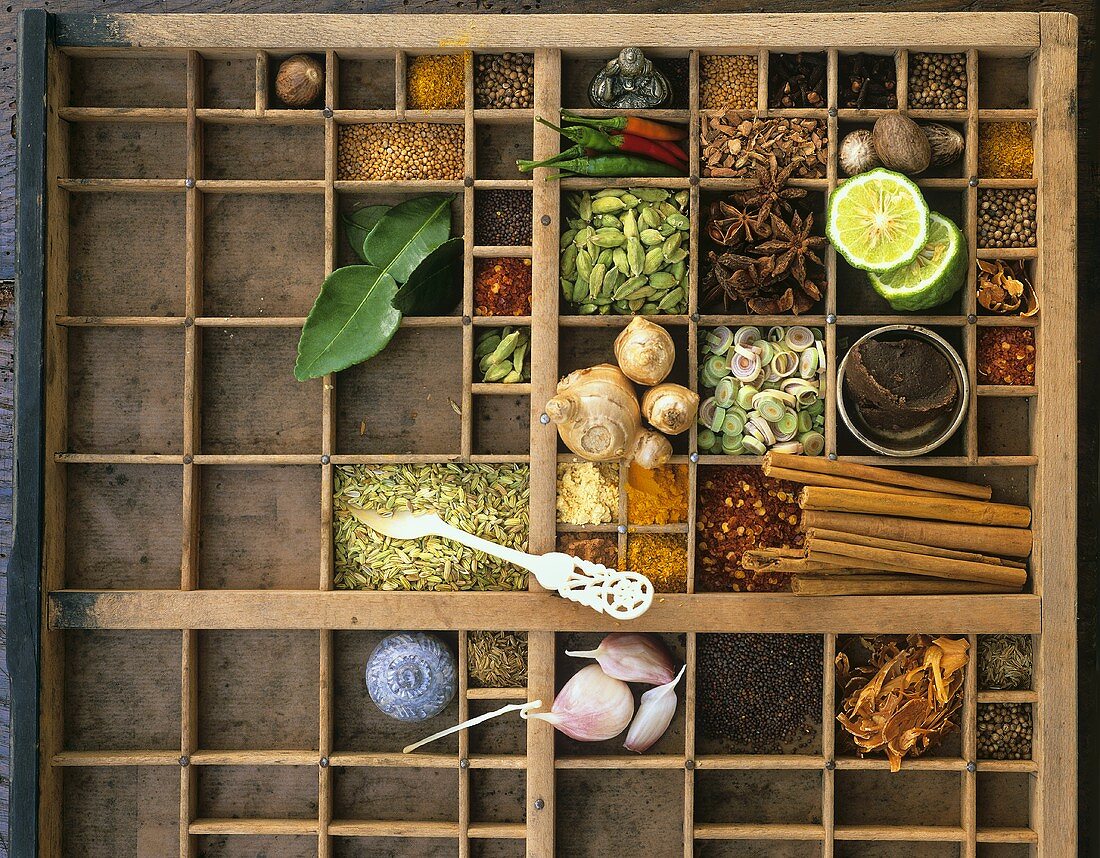 Assorted spices and kaffir limes in typesetter's box