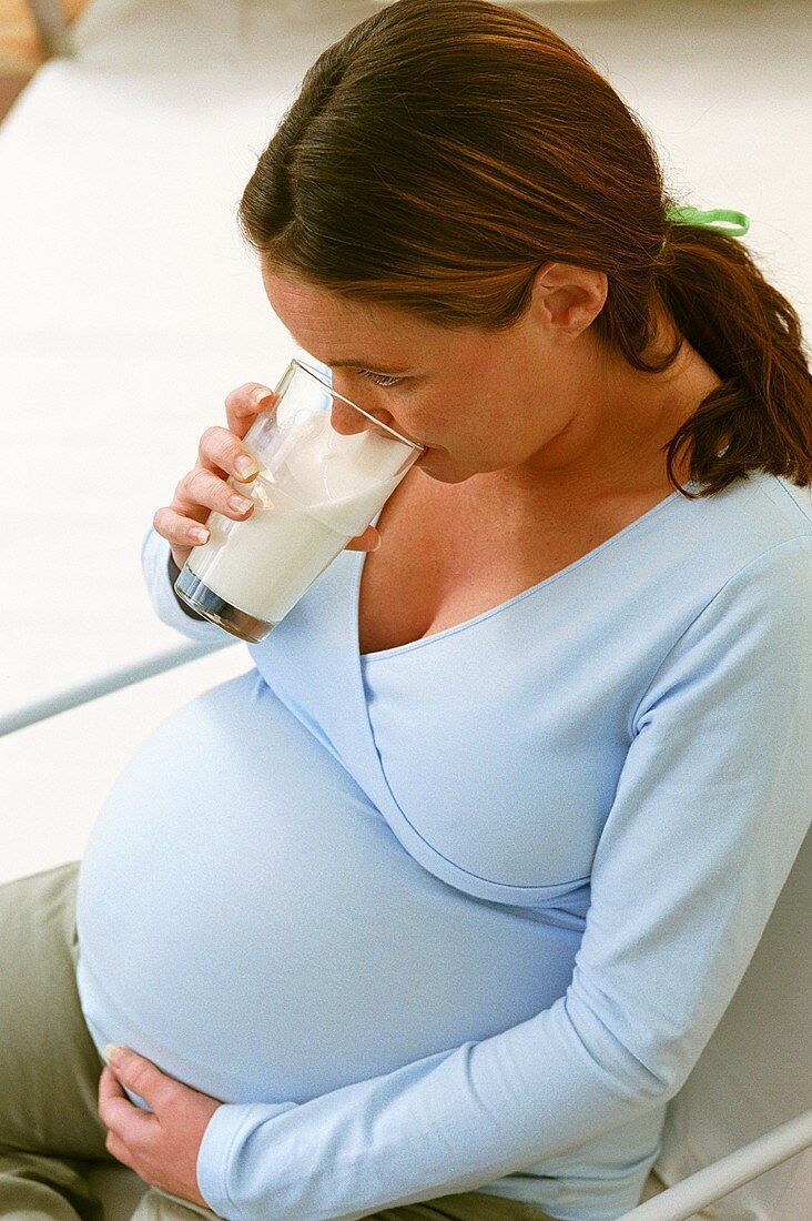 Pregnant woman drinking glass of milk