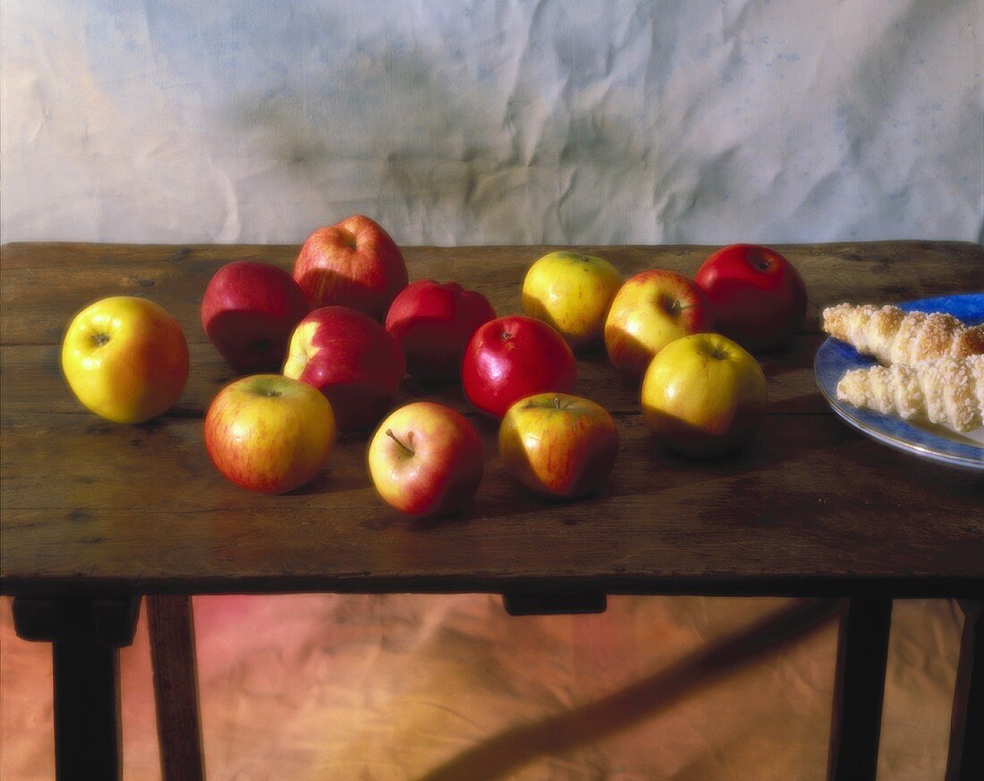 Various types of apples and baked goods on a wooden table