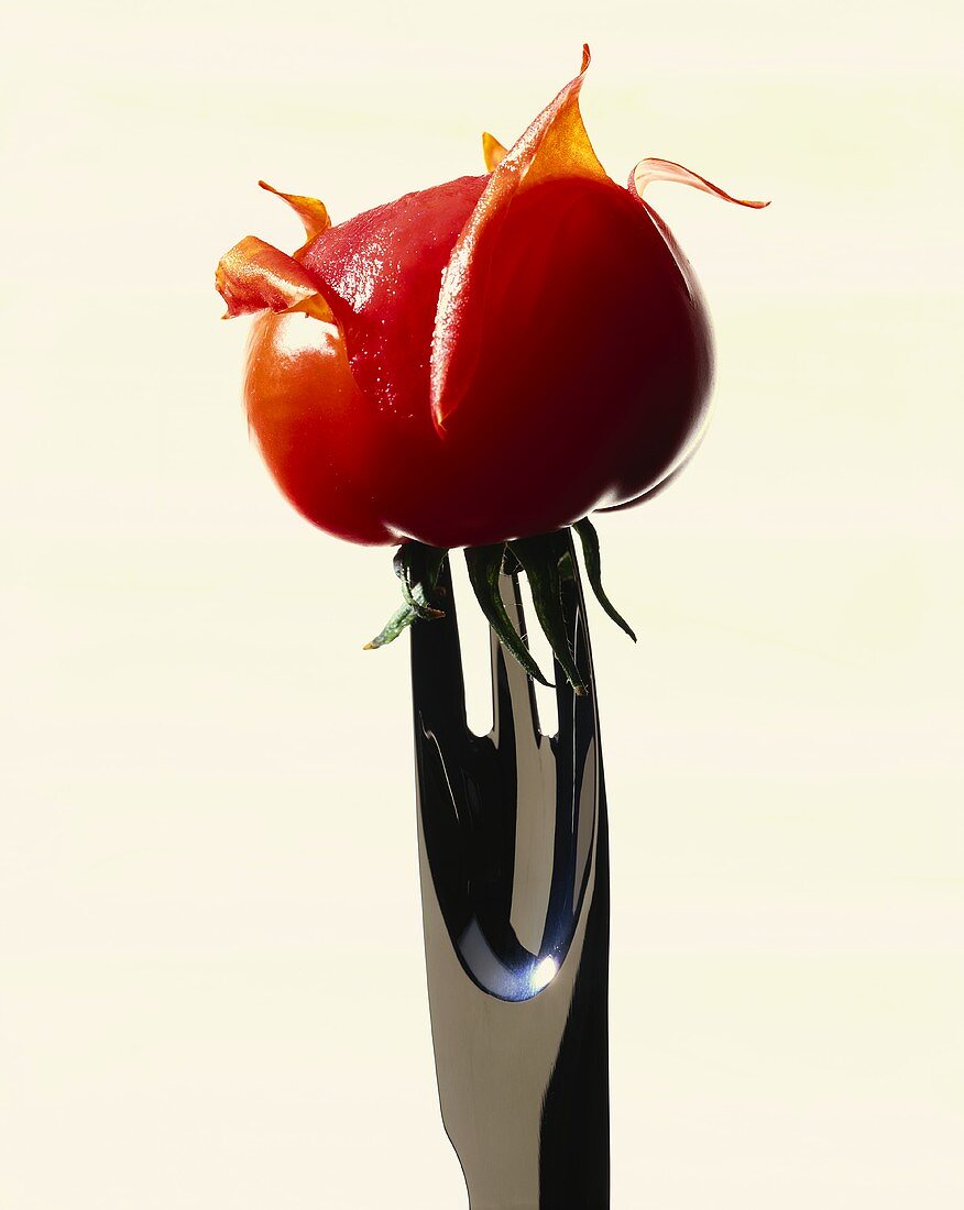 Skinning tomatoes (tomato on a potato peeling fork)