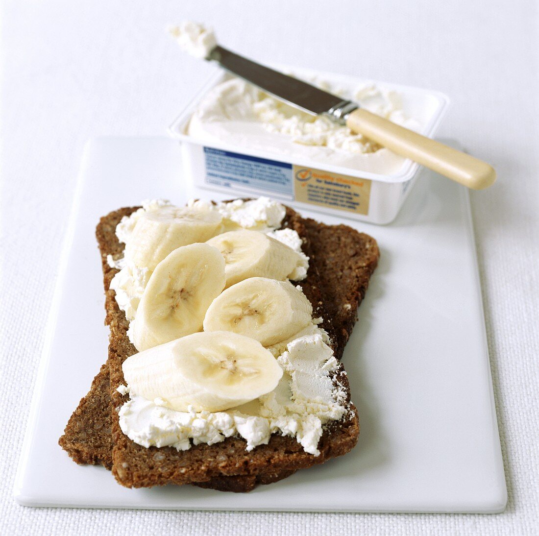 Wholemeal bread topped with soft cheese and banana slices