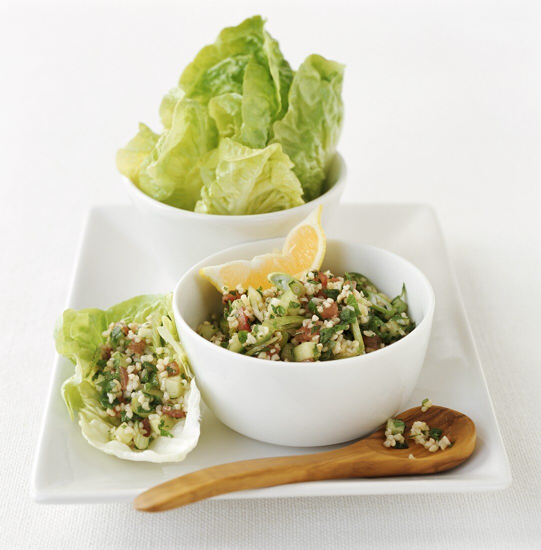 Bulgur wheat salad (tabbouleh) in small bowl & on lettuce leaf