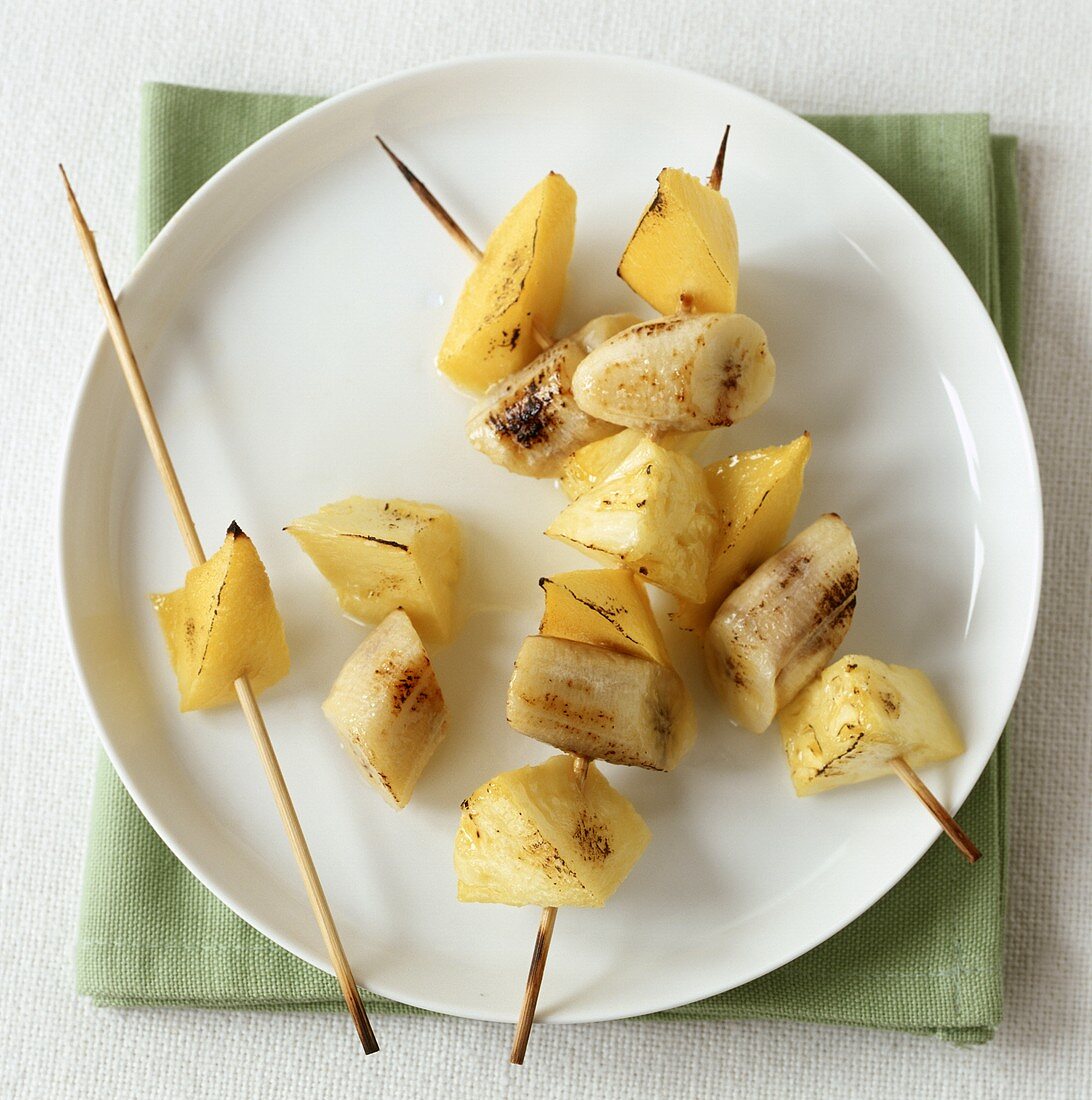 Grilled fruit kebabs with pieces of pineapple, banana & mango
