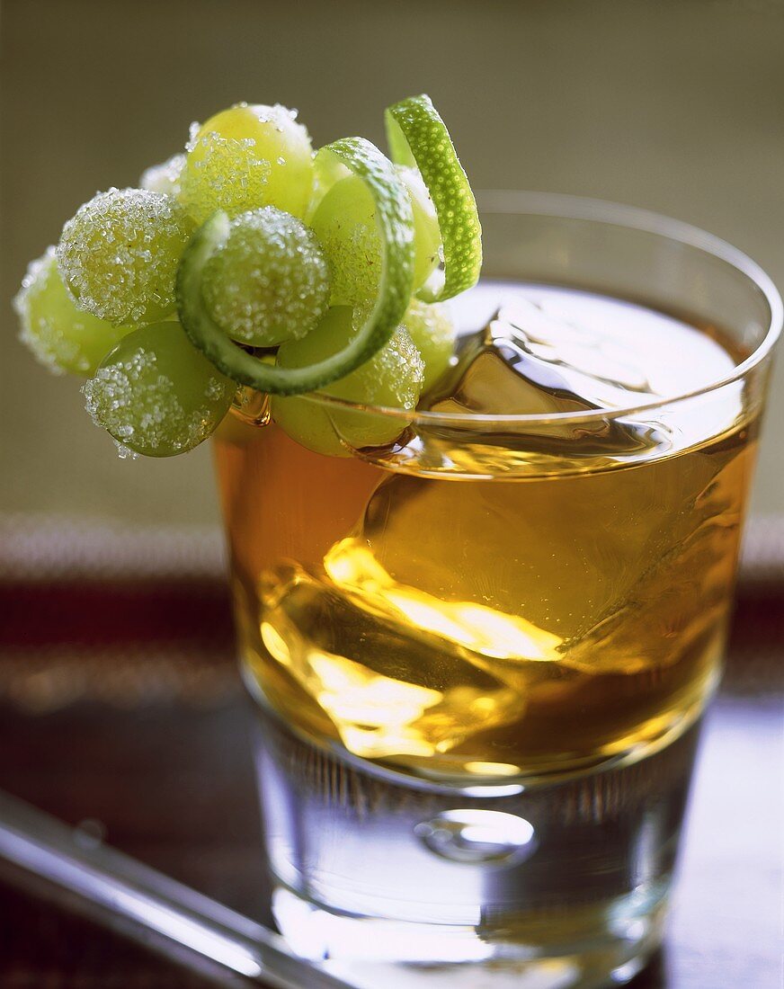 Whiskey cooler in glass, garnished with grapes