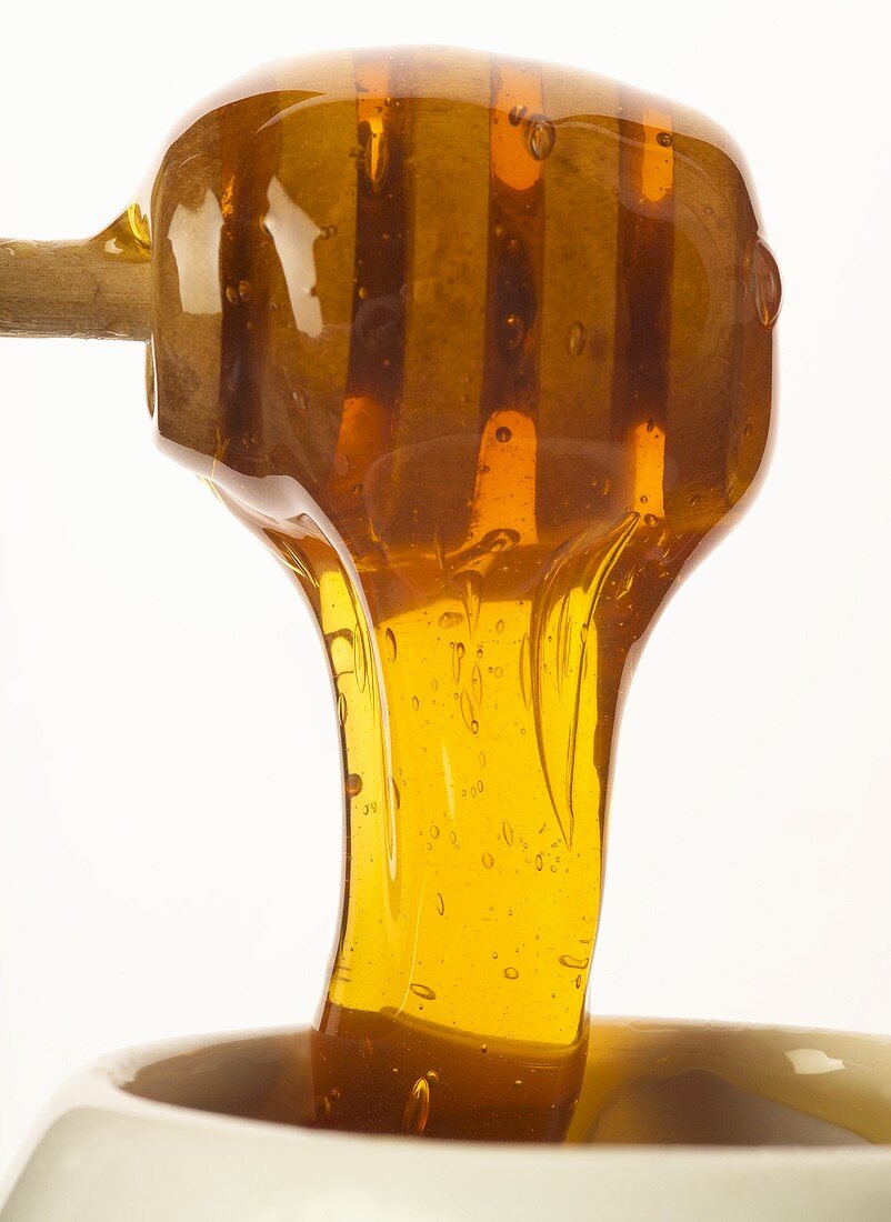 Honey running from a honey dipper (close-up)