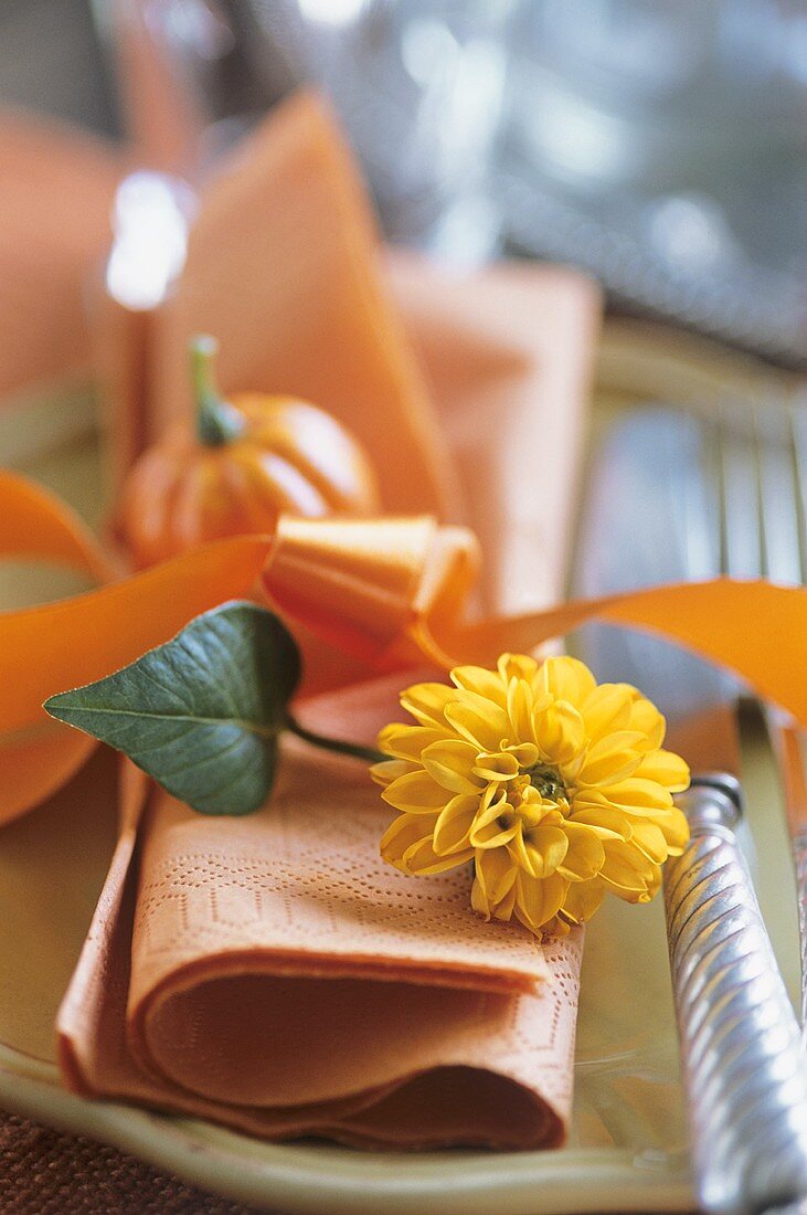 A napkin decorated with a dahlia and a pumpkin