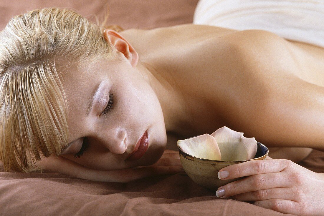 Young woman lying on her stomach, relaxing