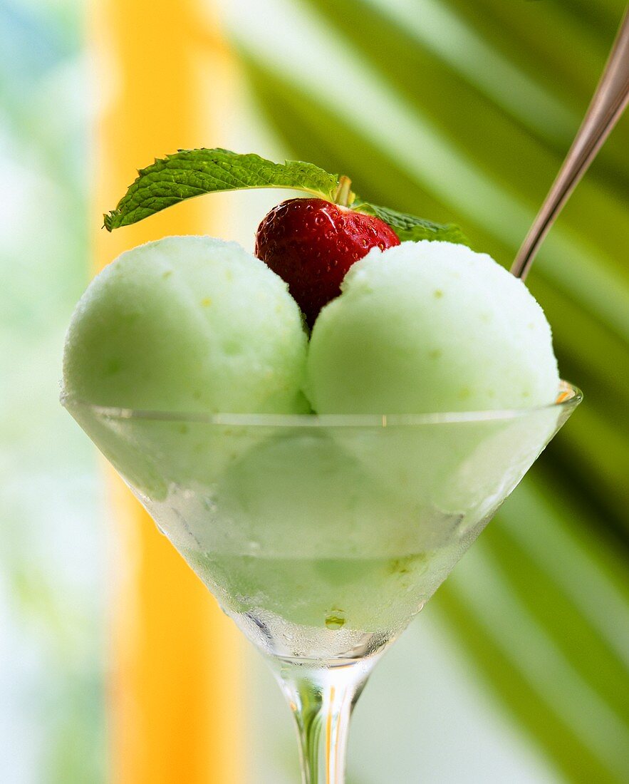 Three scoops of kiwi & lime ice cream decorated with strawberry