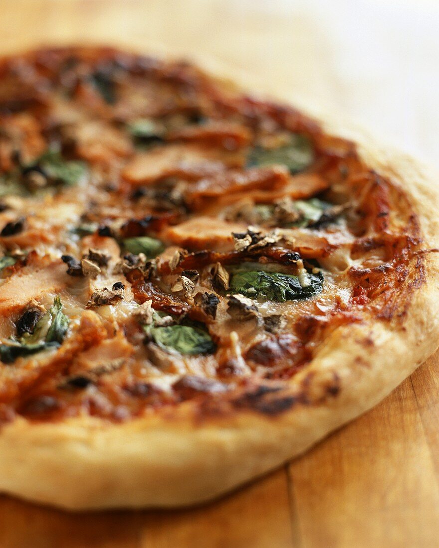 Pizza with dried tomatoes, spinach and mushrooms