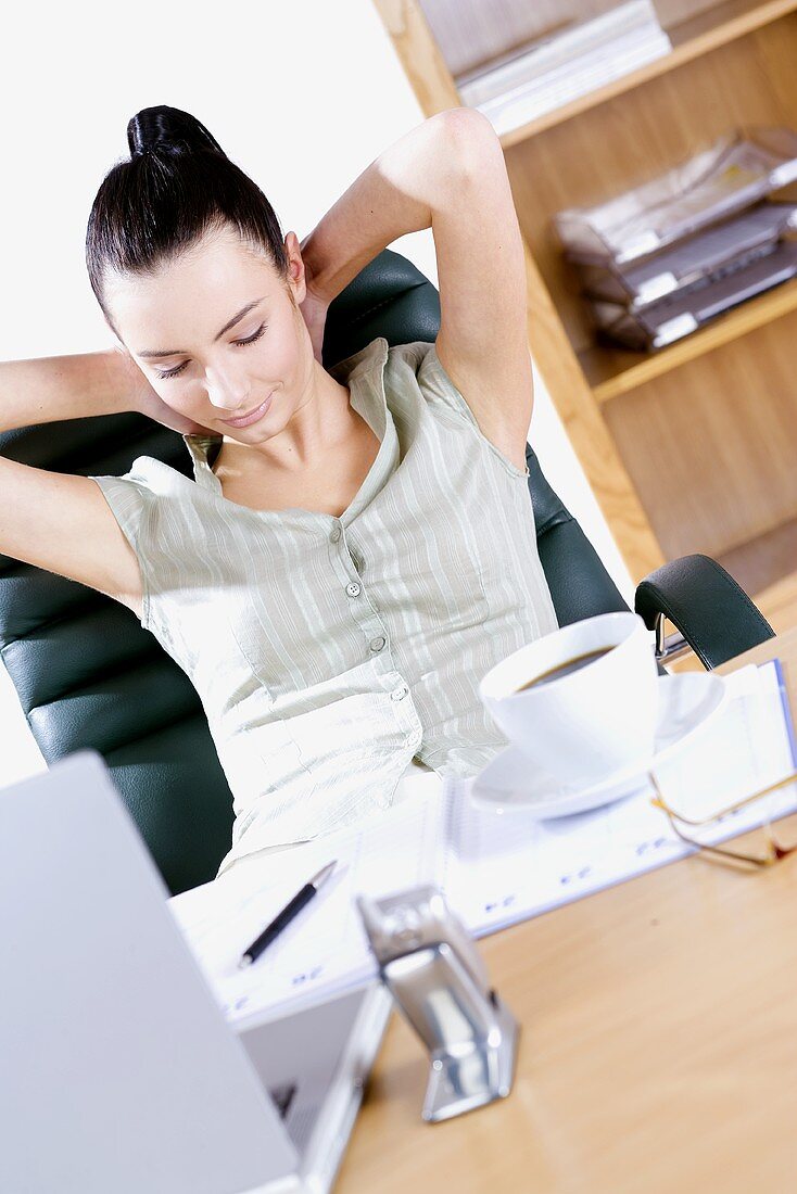Young woman sitting on an office chair, relaxed