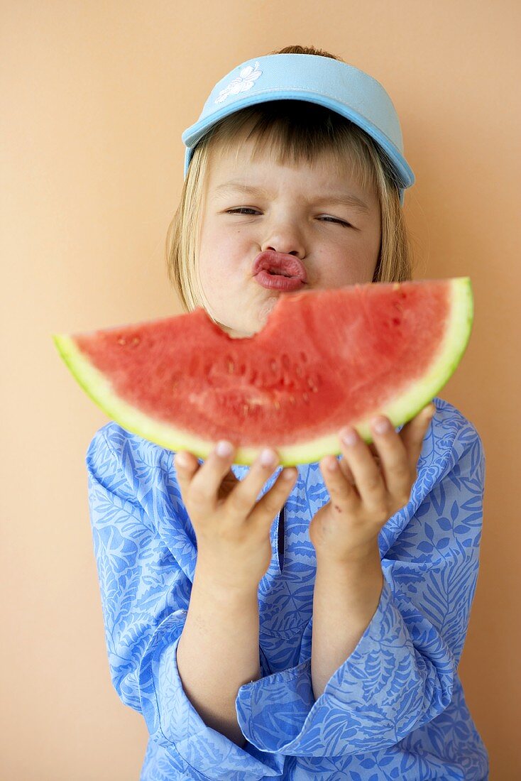 Mädchen hält angebissenen Melonenschnitz