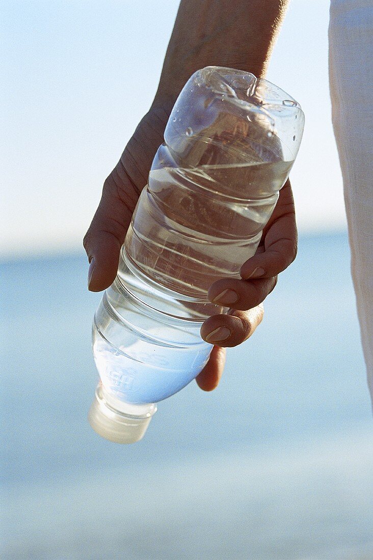 Hand hält Wasserflasche