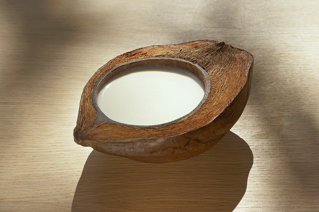 Kokosmilch in einer halben Kokosnuss
