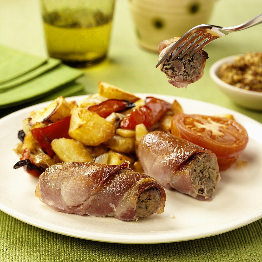 Sausages wrapped in ham with roast potatoes