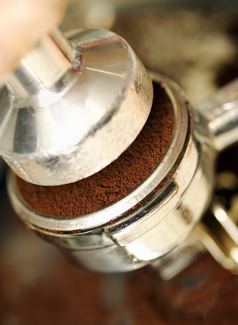 Espressopulver wird in Siebträger gepresst (Nahaufnahme)
