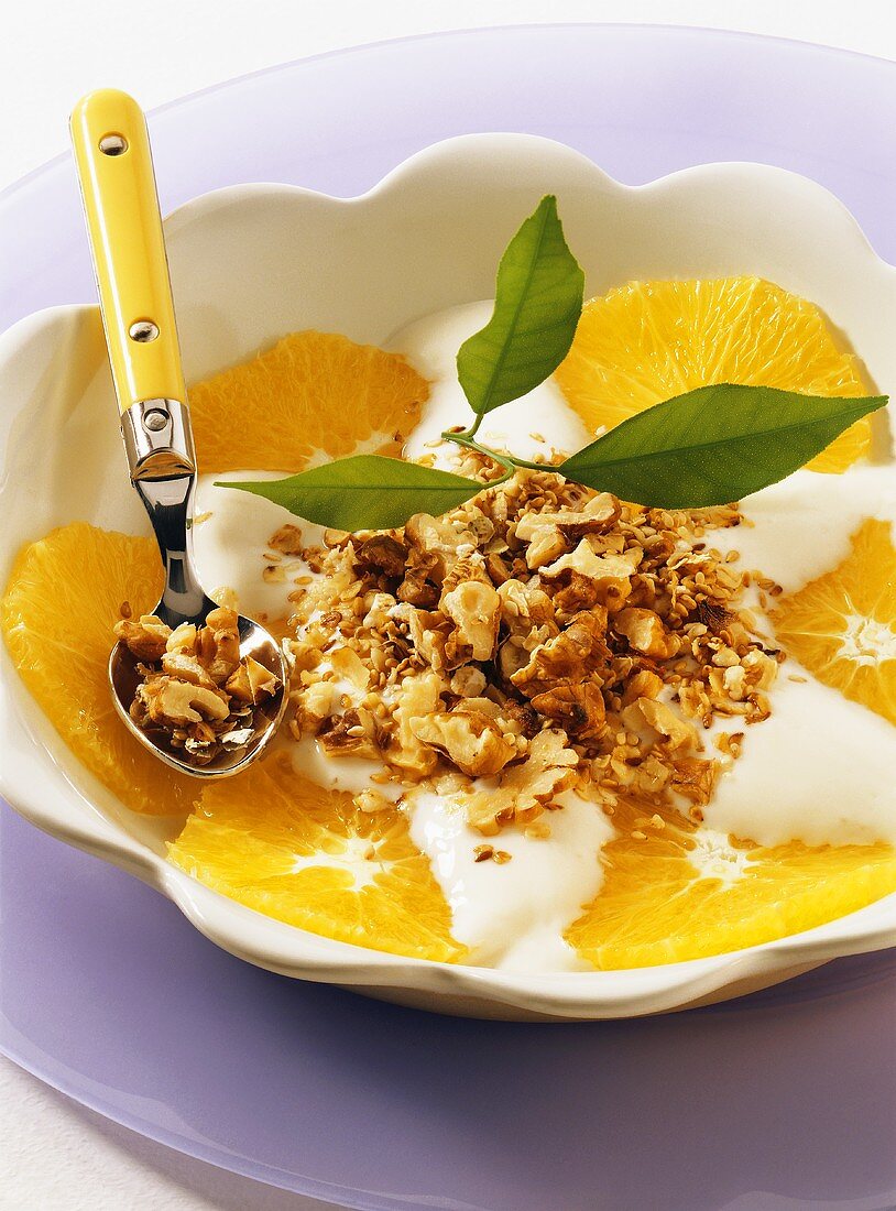 Muesli with nuts, yoghurt and orange slices