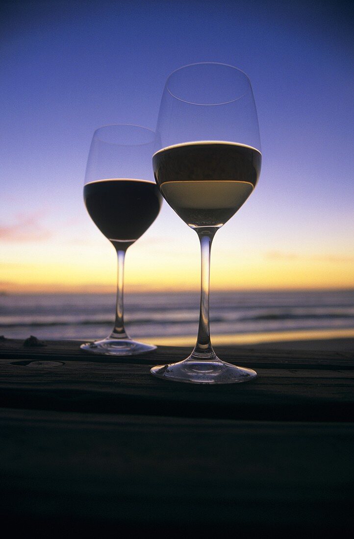 Still life with wine glasses on beach at twilight