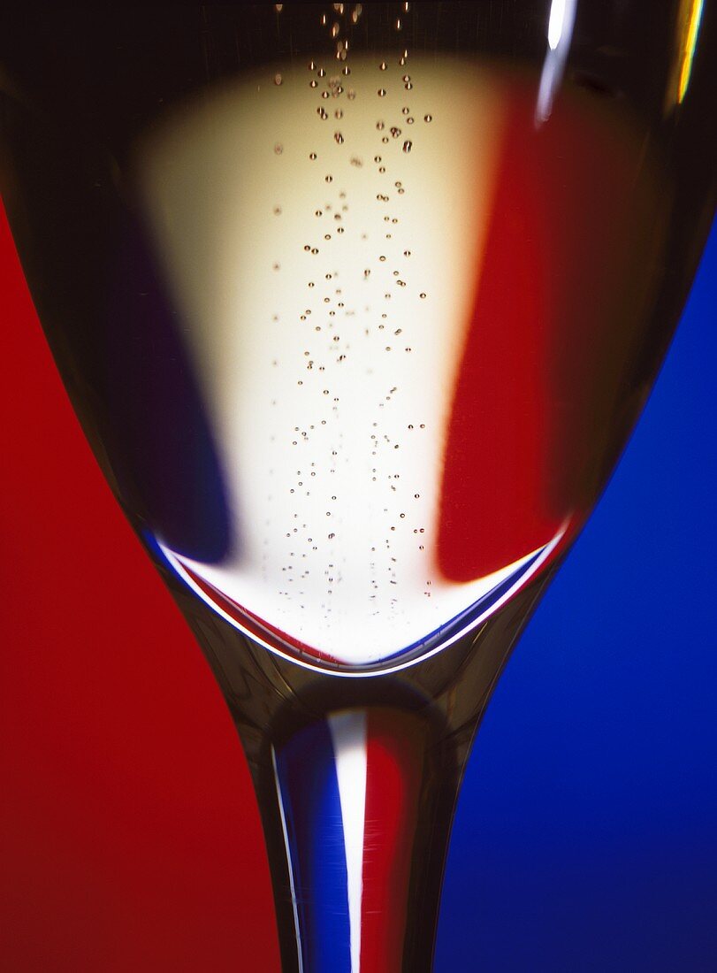 Champagnerglas mit der französischen Trikolore im Hintergrund