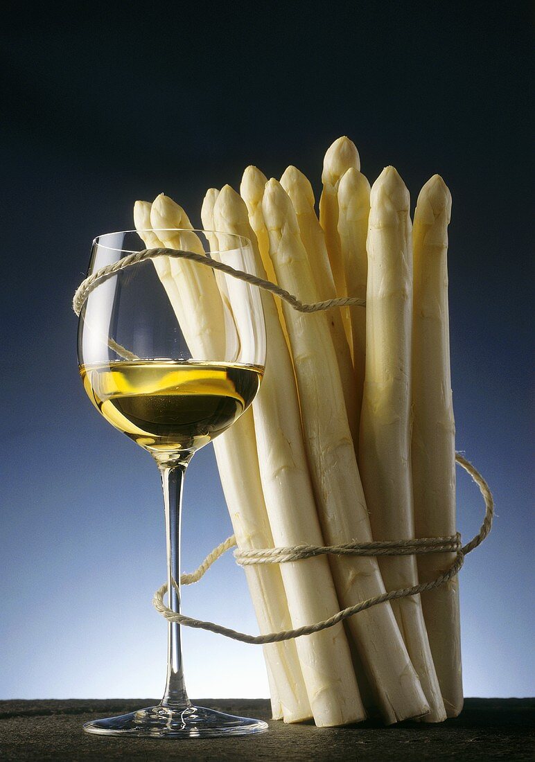 A bundle of fresh white asparagus with wine