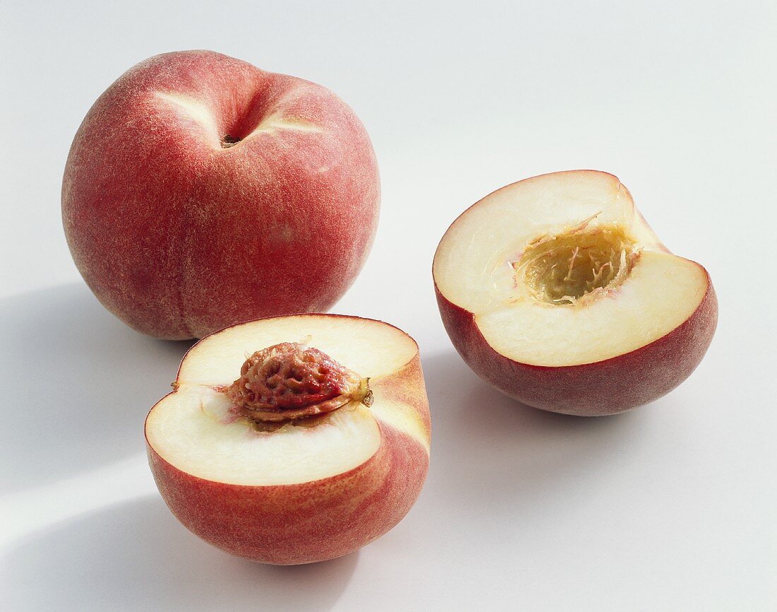 Peaches (Prunus persica), variety ‘Vermeil’, whole & halved