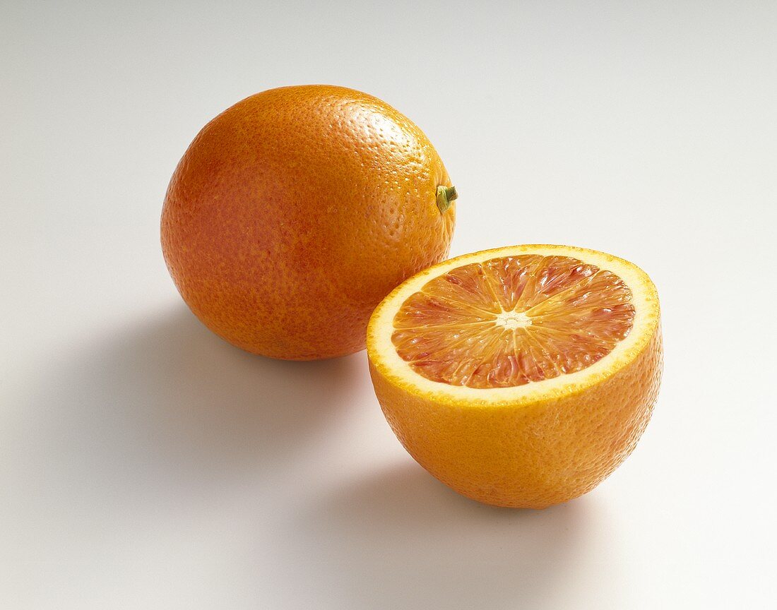 Blutorangen (Citrus sinensis), ganz und halbiert
