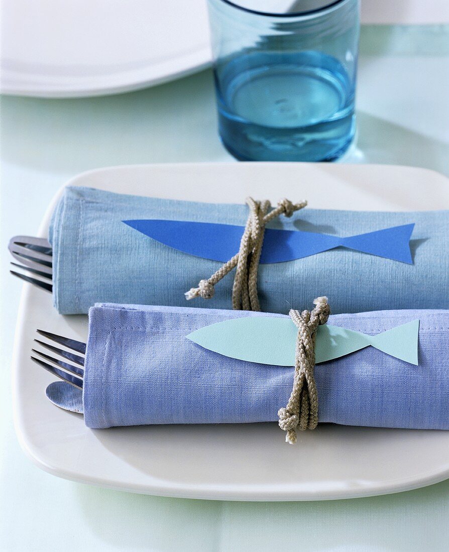 Two sets of cutlery wrapped in napkins