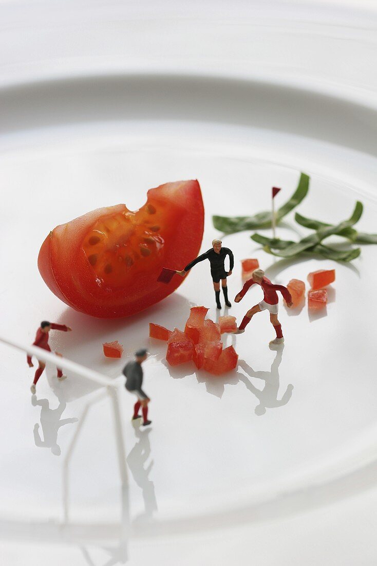 Fussballfiguren trainieren auf Teller mit Tomatenwürfeln