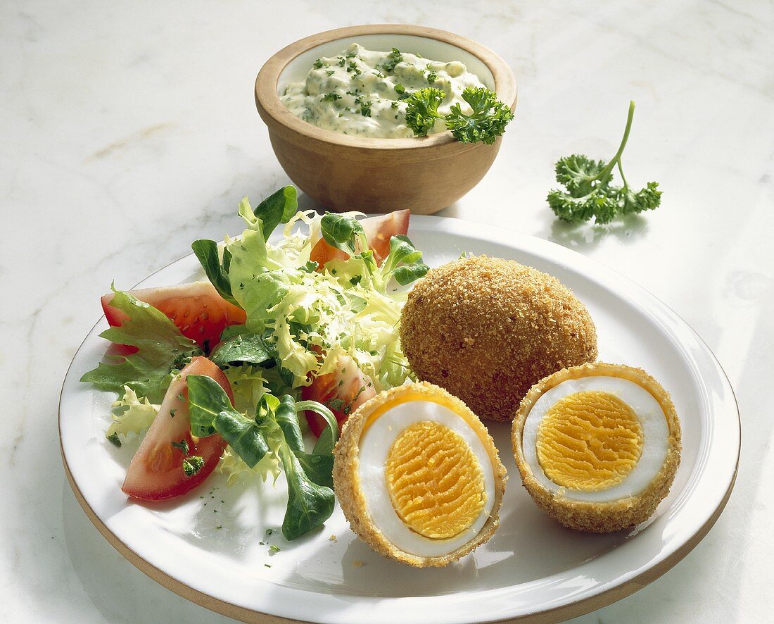 Breaded, deep-fried boiled eggs with salad and herb quark 