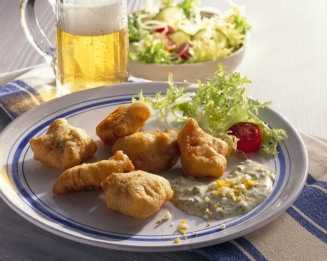 Deep-fried fish in beer batter with salad and beer