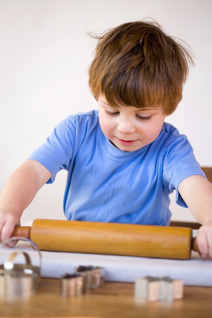 Boy rolling out biscuit dough
