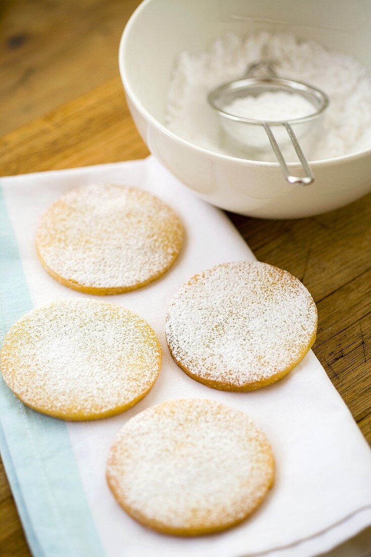 Four round biscuits dusted with icing sugar