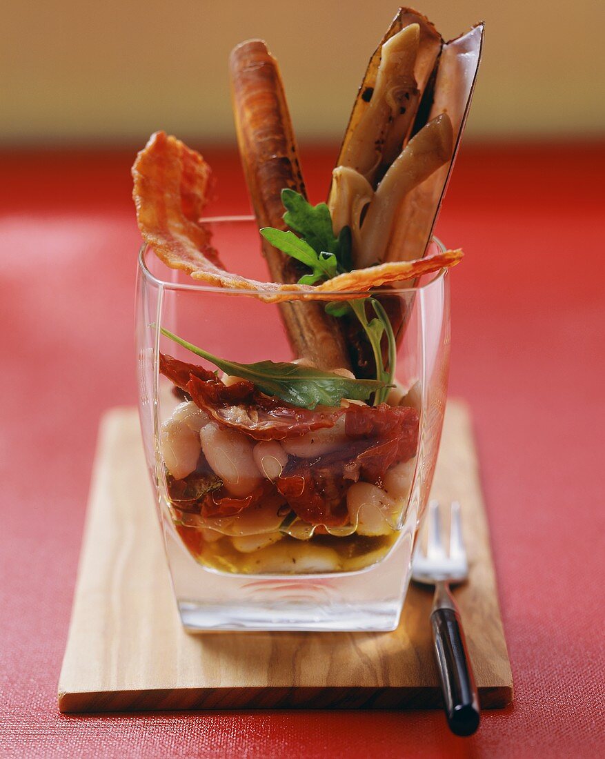 Razor shell salad with bacon and white beans in glass