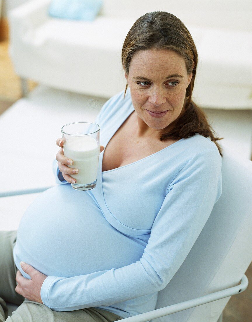Schwangere Frau trinkt Glas Milch