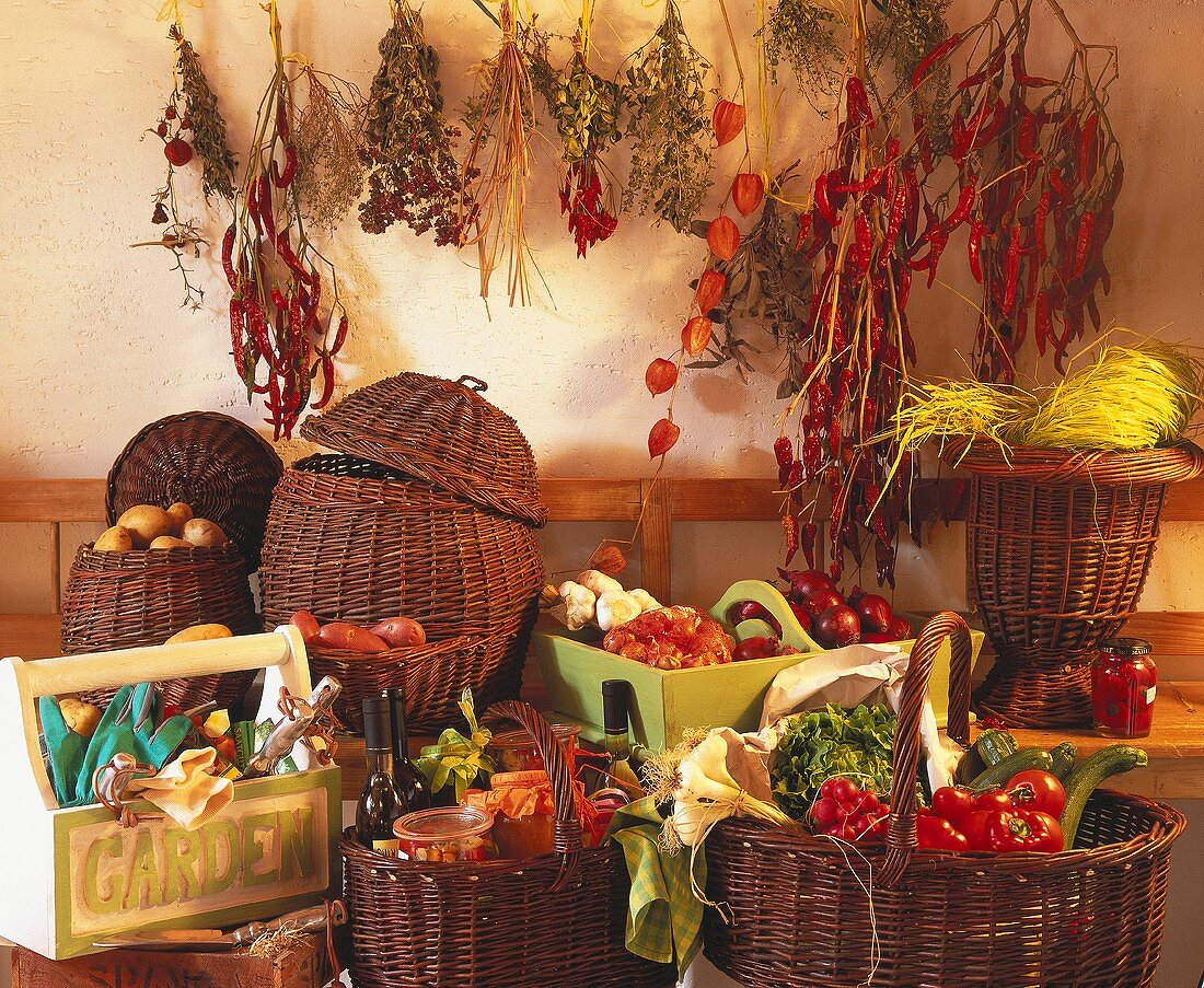 Baskets of vegetables, preserves; herbs etc. on wall