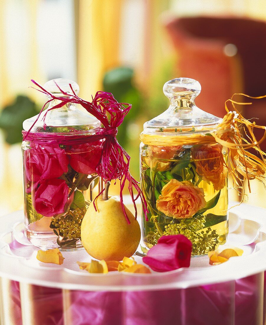Glass containers with rose water and flowers