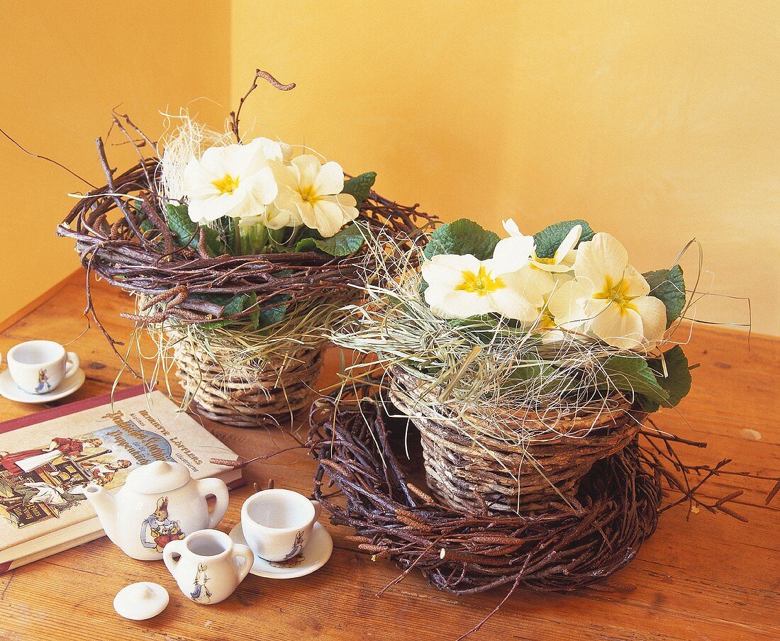 Children's tableware with hare motif & primulas in wicker pots