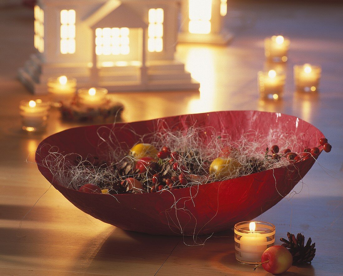 Bowl of berries, fir cones, apples, sisal and tea lights