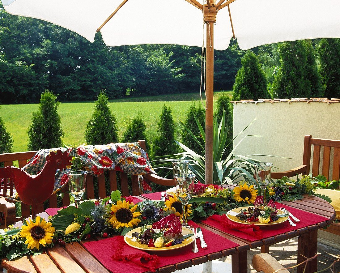 Gedeckter Gartentisch mit Sonnenblumengirlande