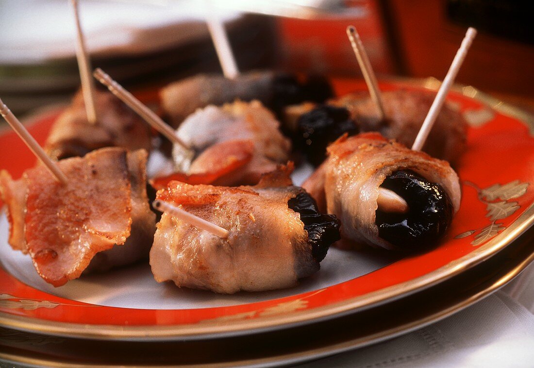 Bacon rolls stuffed with plums & almonds on skewers