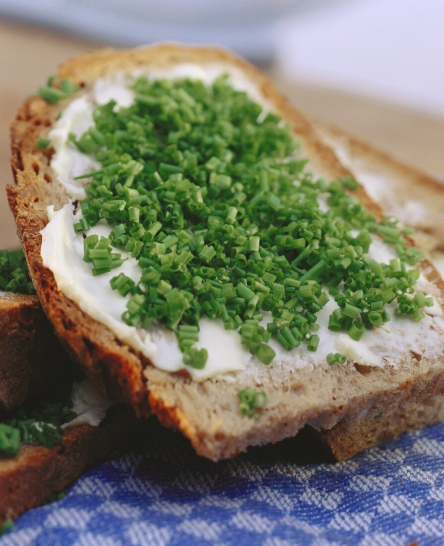 Gebutterte Brotscheibe, mit Schnittlauch bestreut