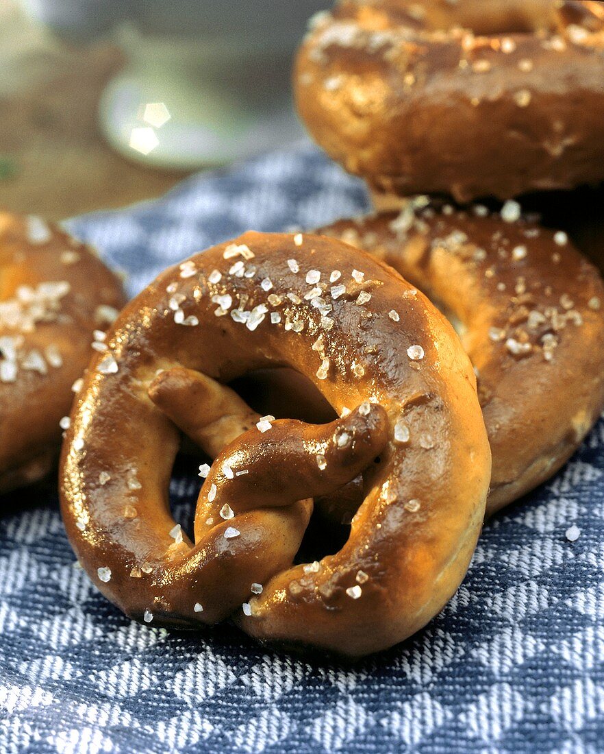 Mehrere Brezen auf blau-weiss kariertem Tuch