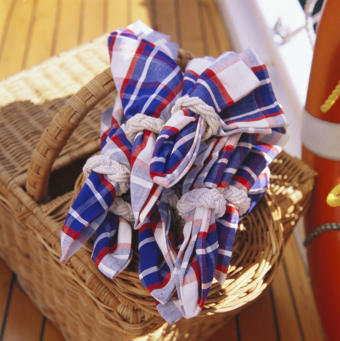 Gefaltete Stoffservietten auf Picknickkorb am Boot