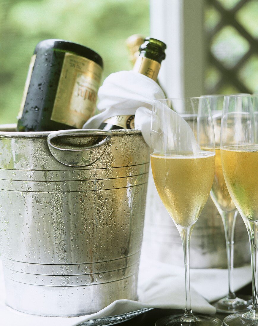 Champagne bottles in champagne buckets & half-full glasses