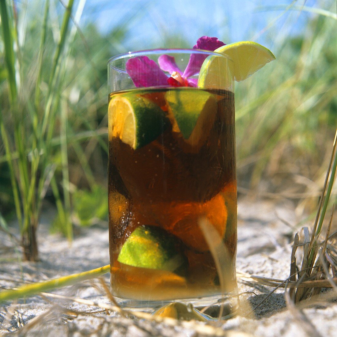 Cuba Libre (Rum-Drink mit Cola) im Sand