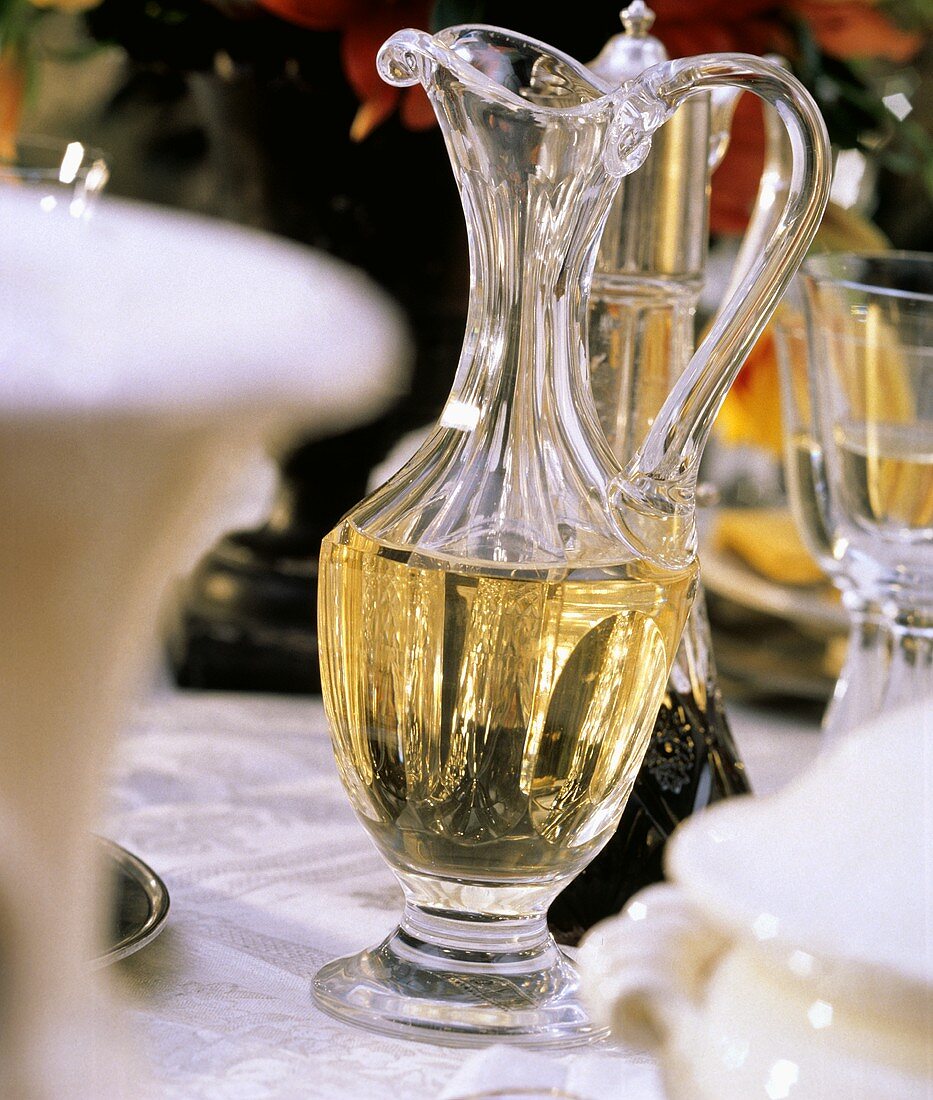 Glaskaraffe mit Weißwein auf dem Tisch