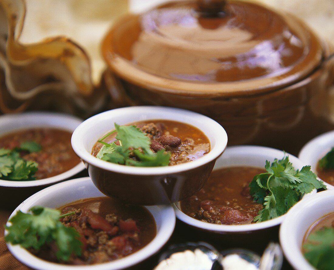 Lots of plates of chili con carne with coriander