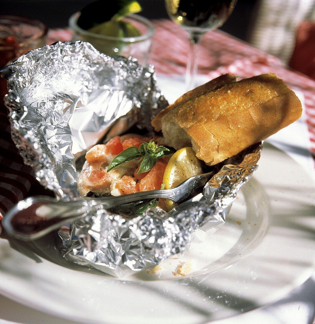 Fish Fillet in Tin Foil; Tomatoes and a Baguette