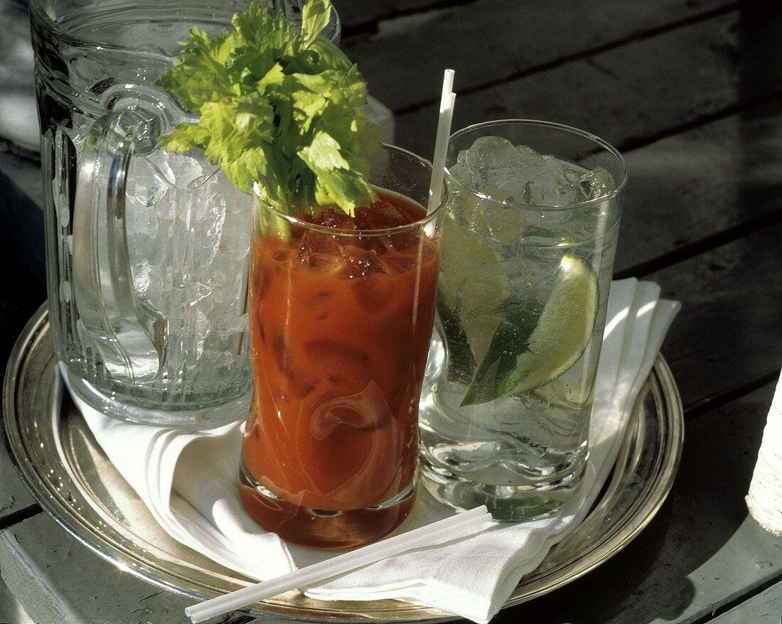 Drinks mit Tomatensaft & Limetten & Glaskrug mit Eiswürfeln