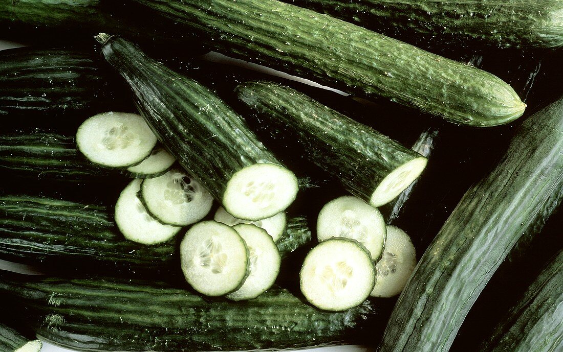 Several Whole Cucumbers with Sliced Cucumbers