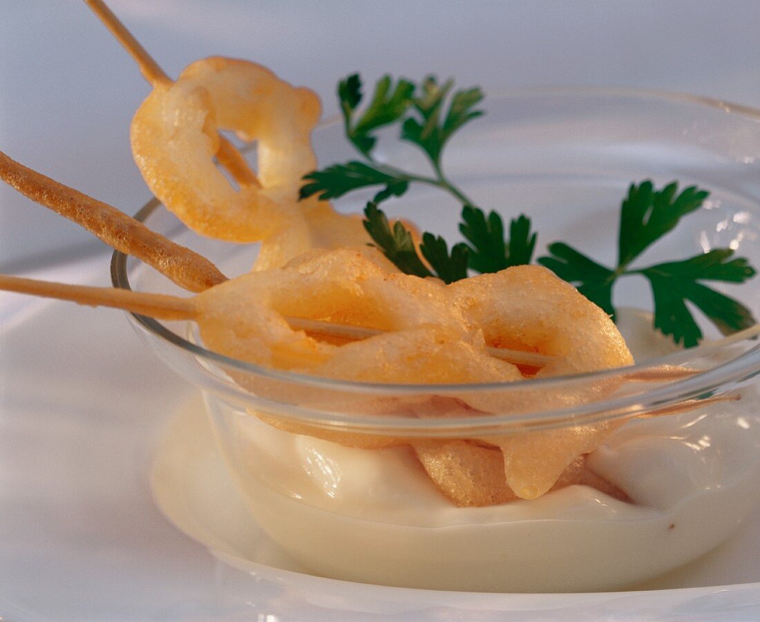 Deep-fried cuttlefish rings on skewer with white sauce